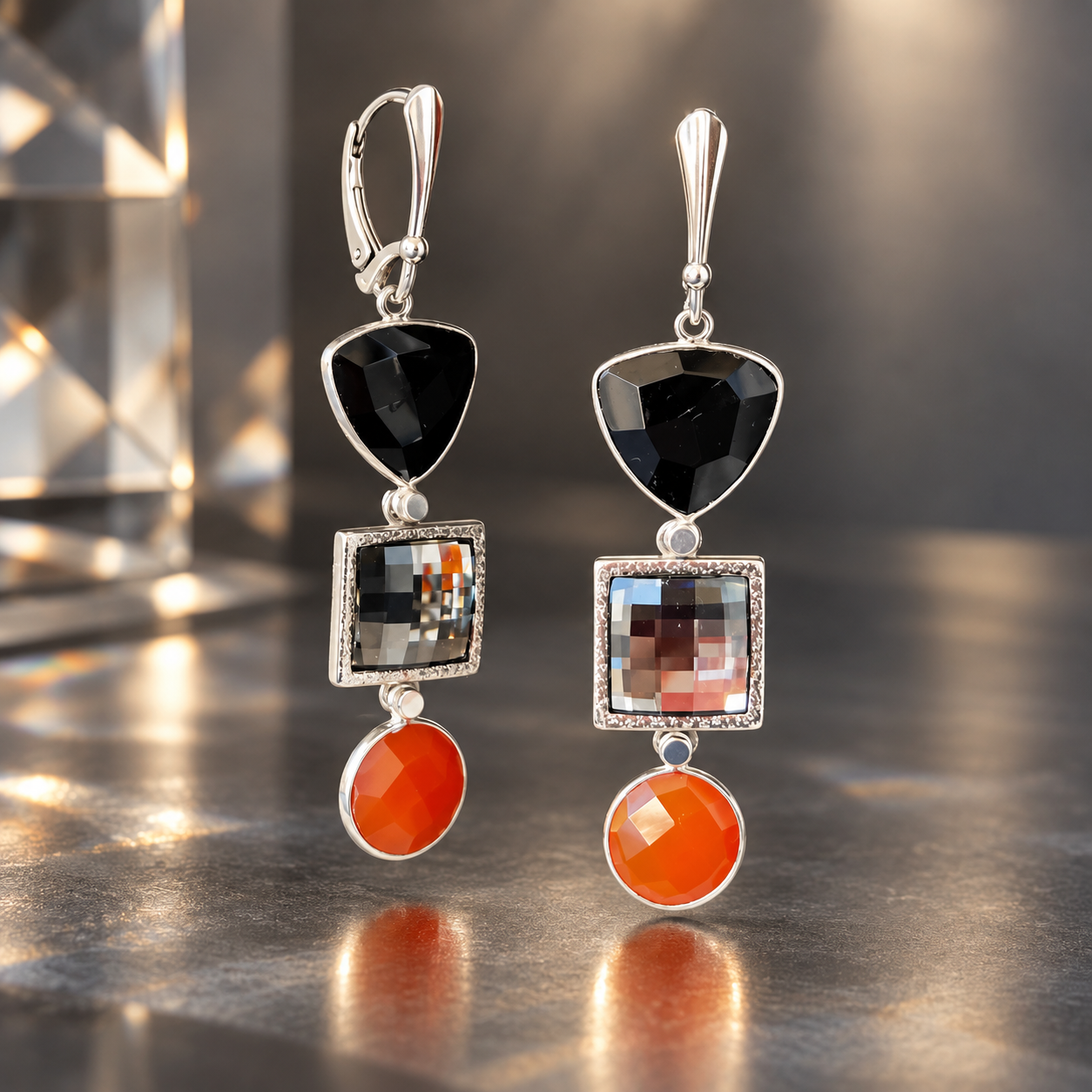 Aurora Eclipse dangle earrings featuring square-faceted silvery Swarovski crystals, faceted black onyx and red topaz drops in textured sterling silver settings with lever back ear wires.