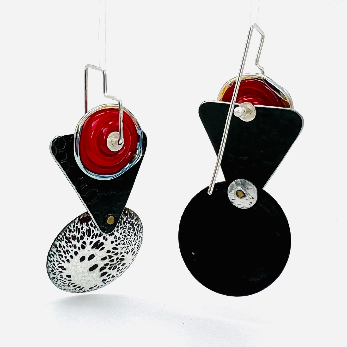 The back of these earrings are also beautifully finished in solid black. Ear wires in sterling silver have been shaped to compliment the design lines of the earrings themselves. These are visible in the past photo. Long in the back, this design insures that the earrings balance well as they dangle gracefully from your ears. These are easy to use as well as secure. These earrings are truly one-of-a-kind! They measure 2 1/8” in total length and are 1" in width.
