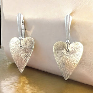 Delicate heart shape dangles in gold