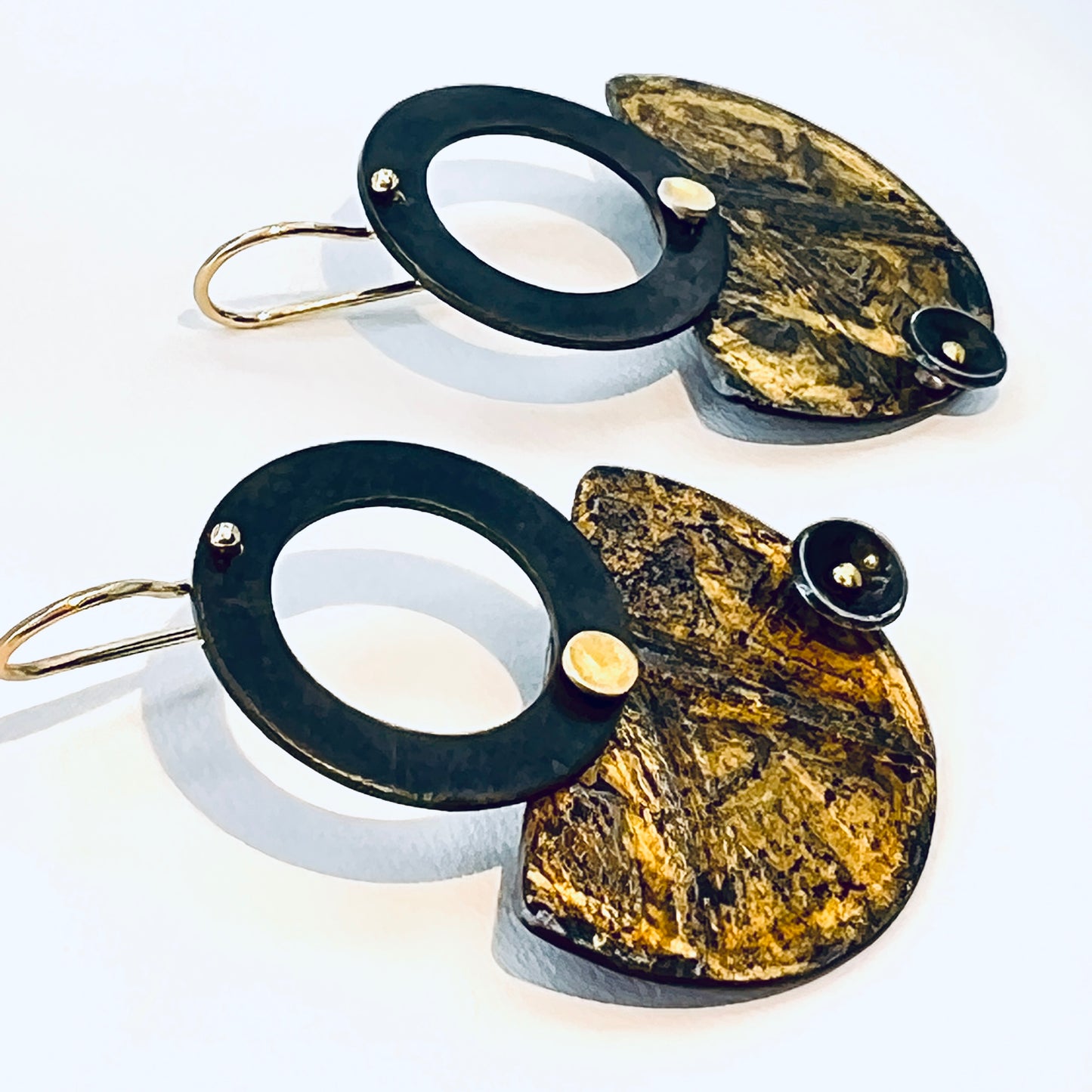 Black and gold steel earrings in geometric shapes